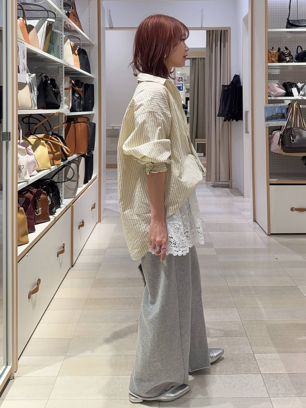 イエロー系のシャツ/ブラウス、ホワイト系のキャミソール、グレー系のスウェットパンツを着用したレディースの春コーディネートの6枚目の写真