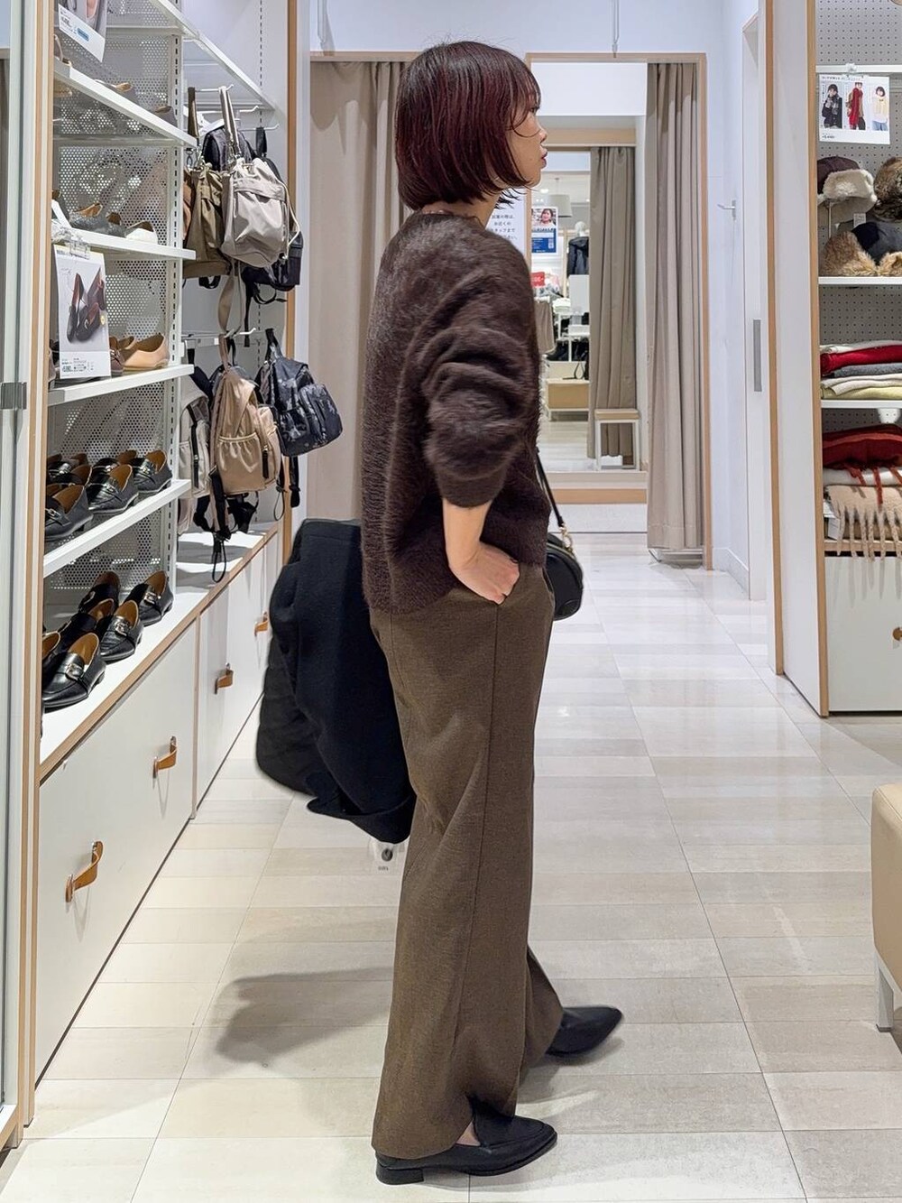 ブラック系のステンカラーコート、ブラウン系のその他パンツ、ブラック系のパンプスを着用したレディースの秋コーディネートの5枚目の写真