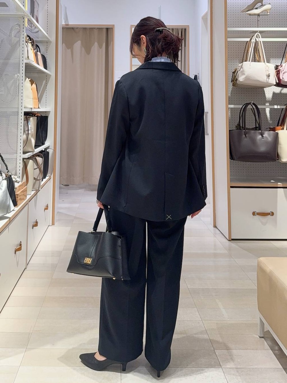 ブラック系のパンプス、ブルー系のシャツ/ブラウス、ブルー系のテーラードジャケットを着用したレディースの冬コーディネートの7枚目の写真