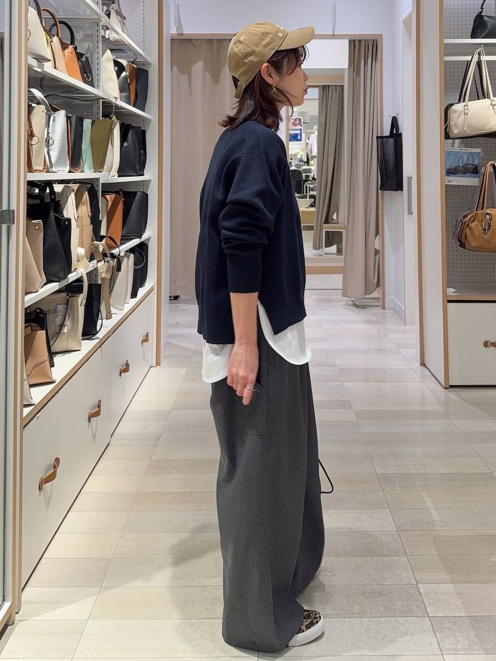 ホワイト系のハンドバッグ、ブルー系のニット/セーター、グレー系のその他パンツを着用したレディースの春コーディネートの4枚目の写真