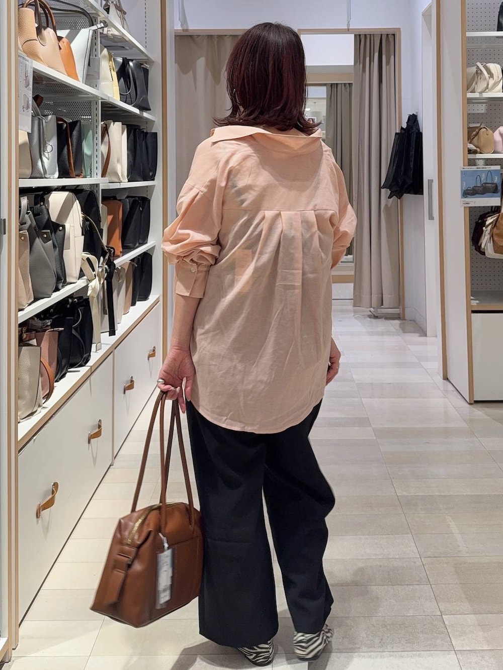 その他のパンプス、ブラウン系のボストンバッグ、シルバー系のネックレスを着用したレディースの春コーディネートの3枚目の写真