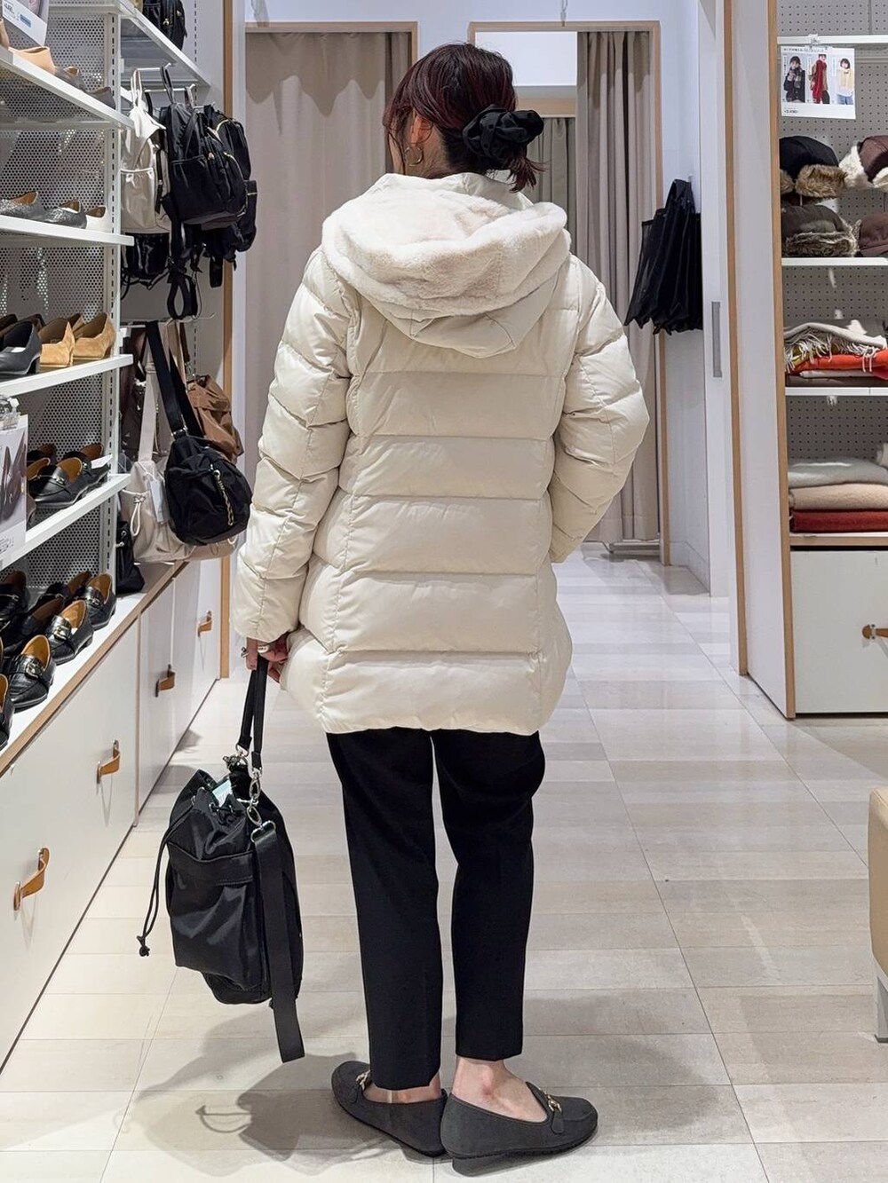 ブラック系のショルダーバッグ、ベージュ系のダウンジャケット/コート、ブラック系のその他パンツを着用したレディースの冬コーディネートの7枚目の写真