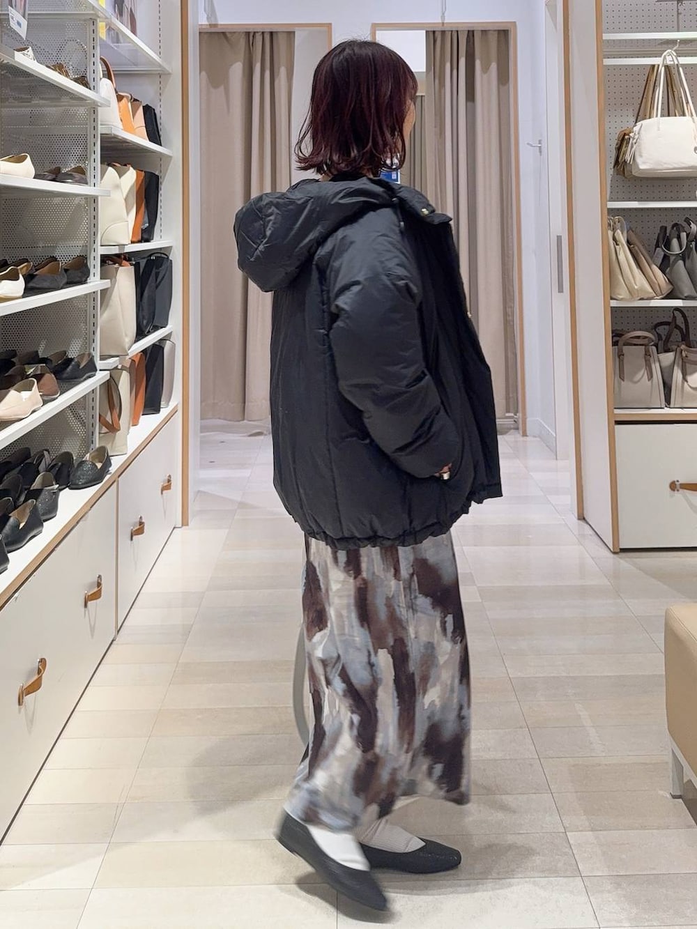 ブラック系のパンプス、ホワイト系のキャミソール、ブルー系のダウンジャケット/コートを着用したレディースの冬コーディネートの4枚目の写真