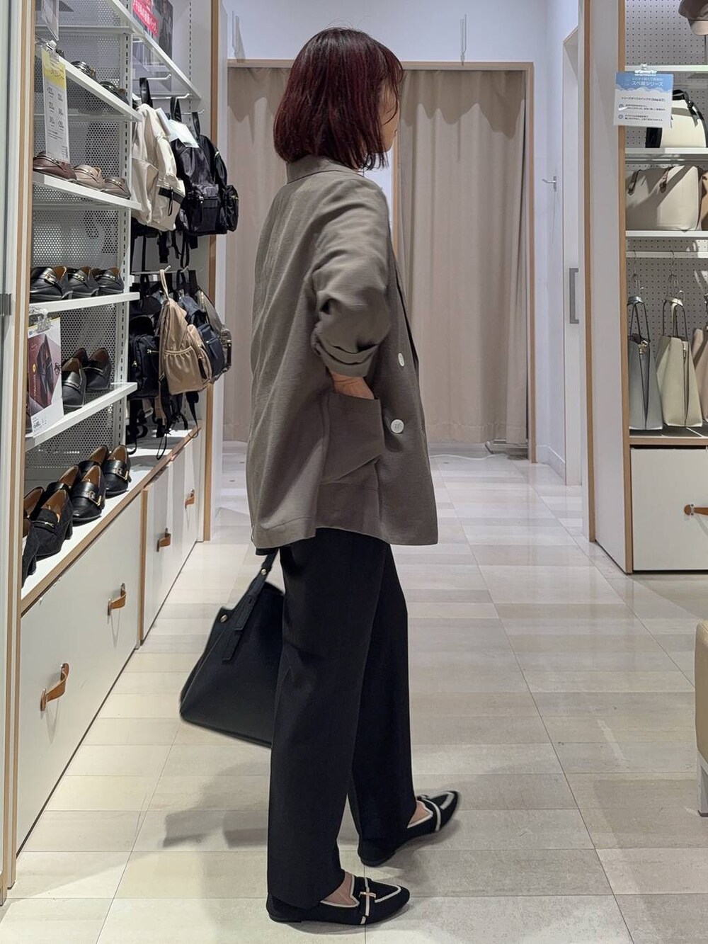 ブラック系のショルダーバッグ、ブラック系のスラックス、その他のパンプスを着用したレディースの秋コーディネートの4枚目の写真