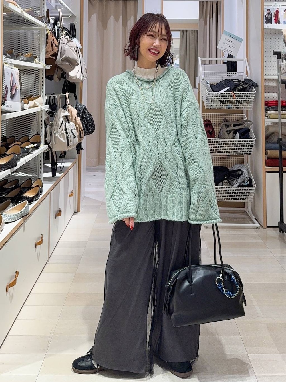 ブルー系のデニムパンツ、イエロー系のショルダーバッグ、ホワイト系のステンカラーコートを着用したレディースの冬コーディネートの3枚目の写真