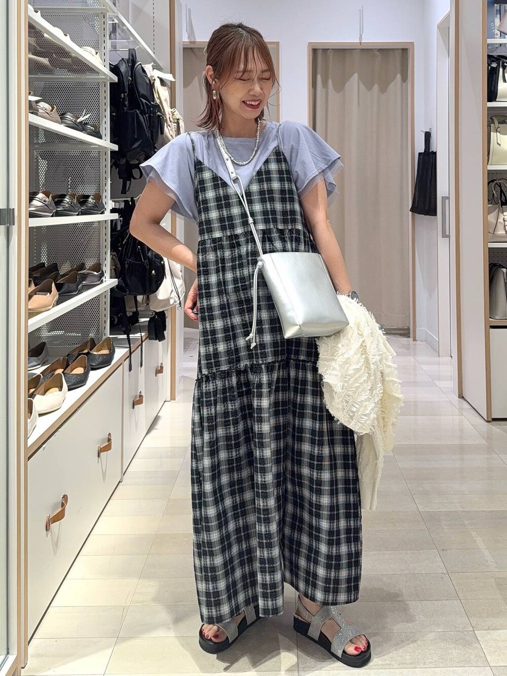 ブラック系のショルダーバッグ、ブラック系のパンプス、ブルー系のその他パンツを着用したレディースの夏コーディネートの3枚目の写真