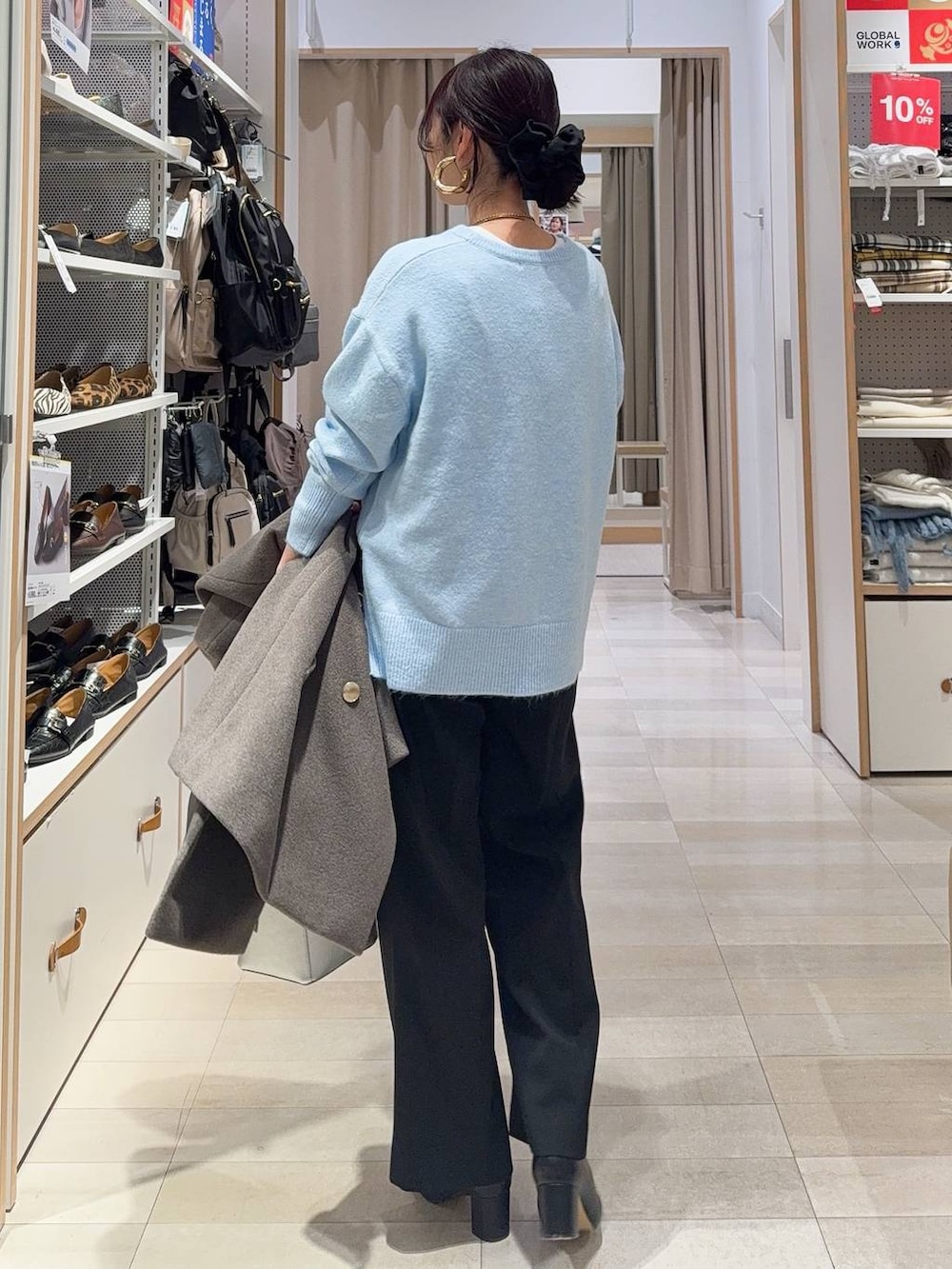 シルバー系のショルダーバッグ、ブラウン系のチェスターコート、ブラック系のその他パンツを着用したレディースの冬コーディネートの7枚目の写真