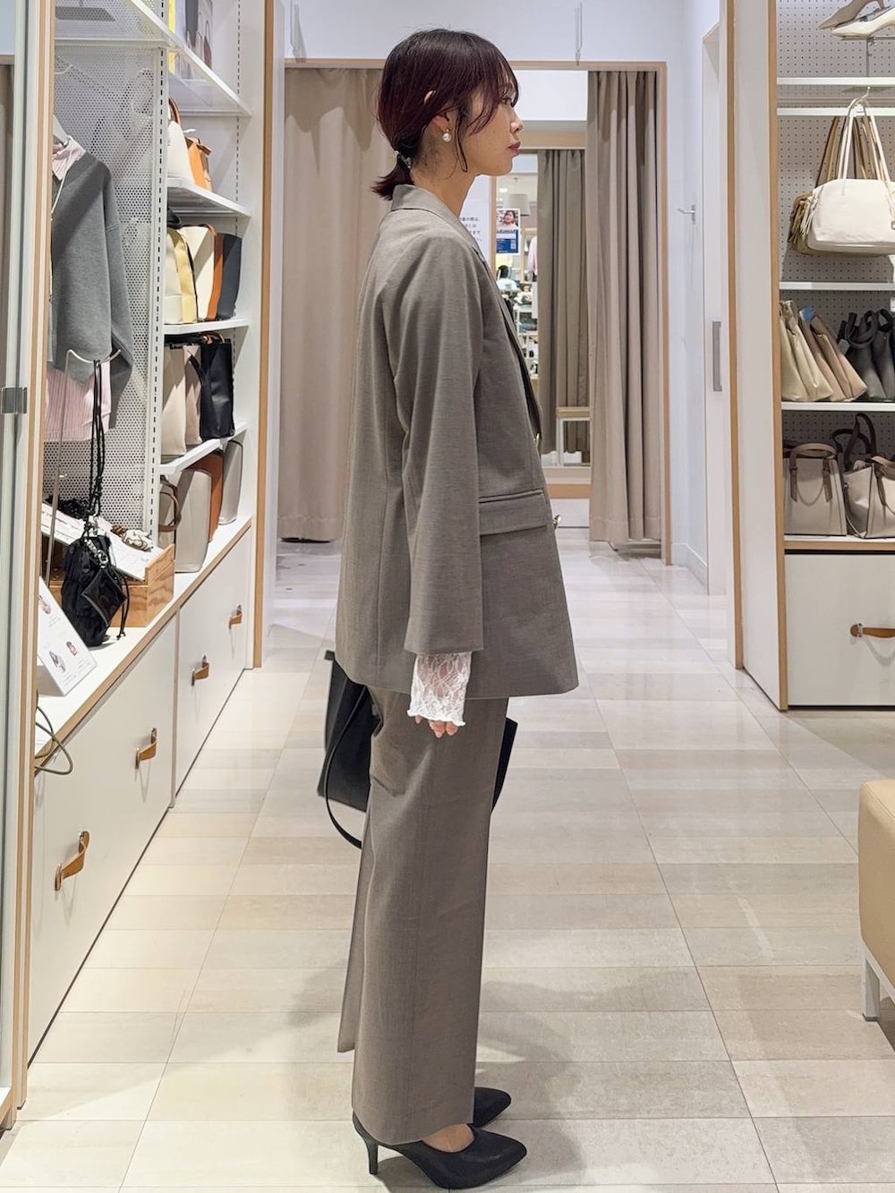 ホワイト系のキャミソール、ホワイト系のTシャツ/カットソー、ブラウン系のスラックスを着用したレディースの冬コーディネートの5枚目の写真