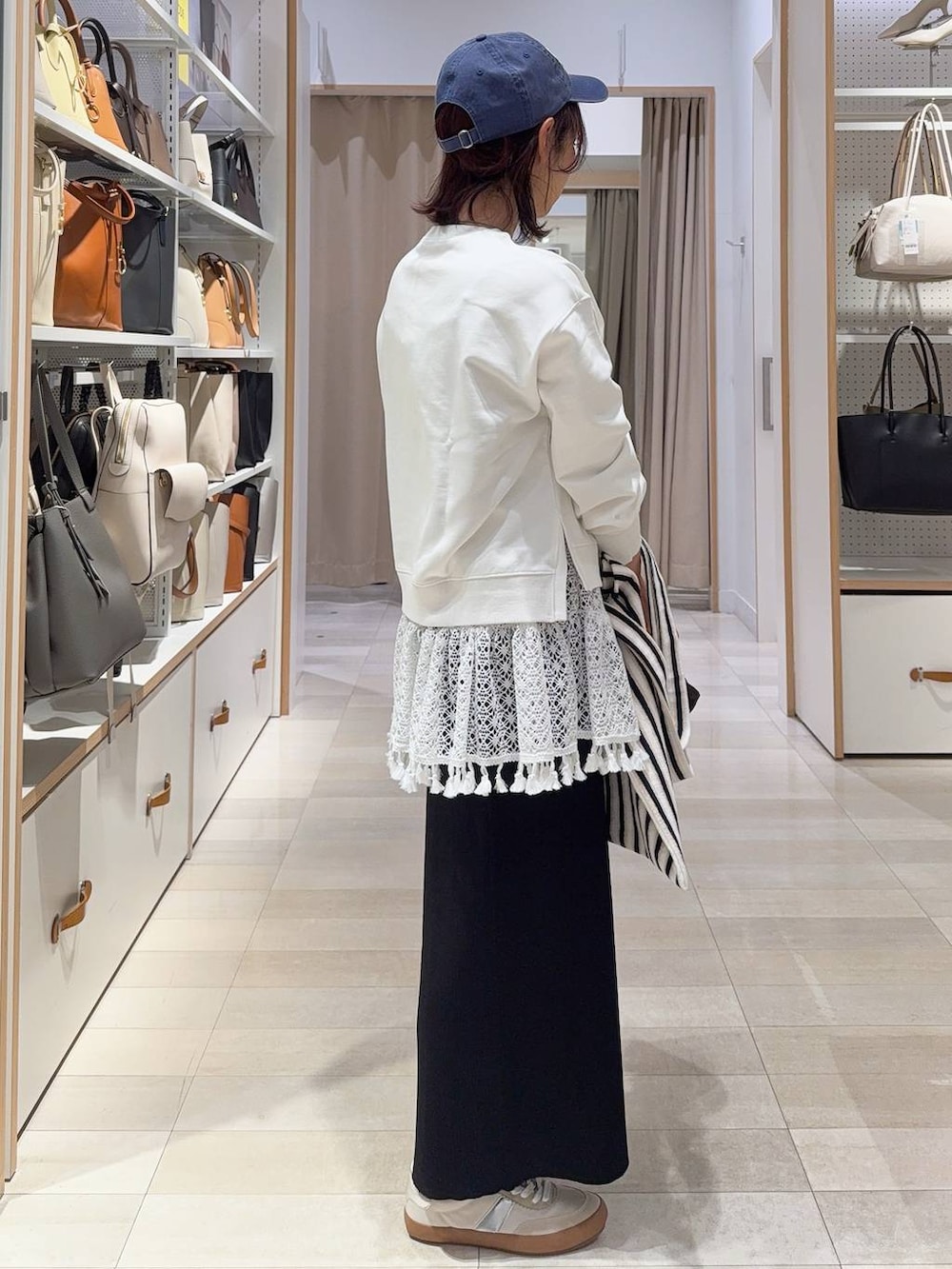 ホワイト系のスニーカー、ホワイト系のスウェット、ホワイト系のトートバッグを着用したレディースの冬コーディネートの5枚目の写真