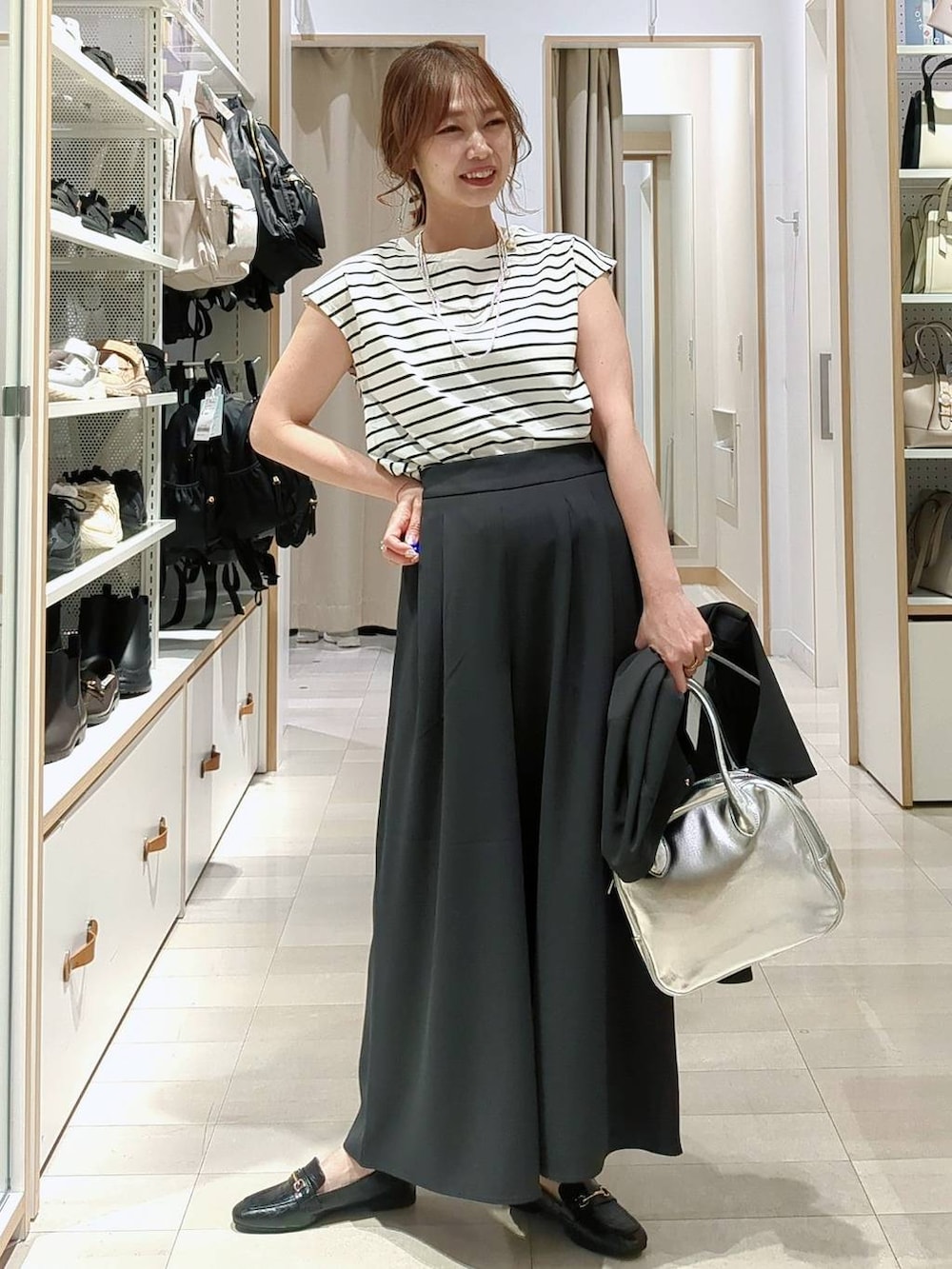 ブラック系のローファー、グレー系のボストンバッグ、ホワイト系のTシャツ/カットソーを着用したレディースの春コーディネートの2枚目の写真