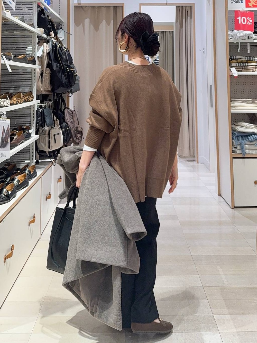 ブラウン系のチェスターコート、ブラック系のその他パンツ、ホワイト系のTシャツ/カットソーを着用したレディースの冬コーディネートの9枚目の写真