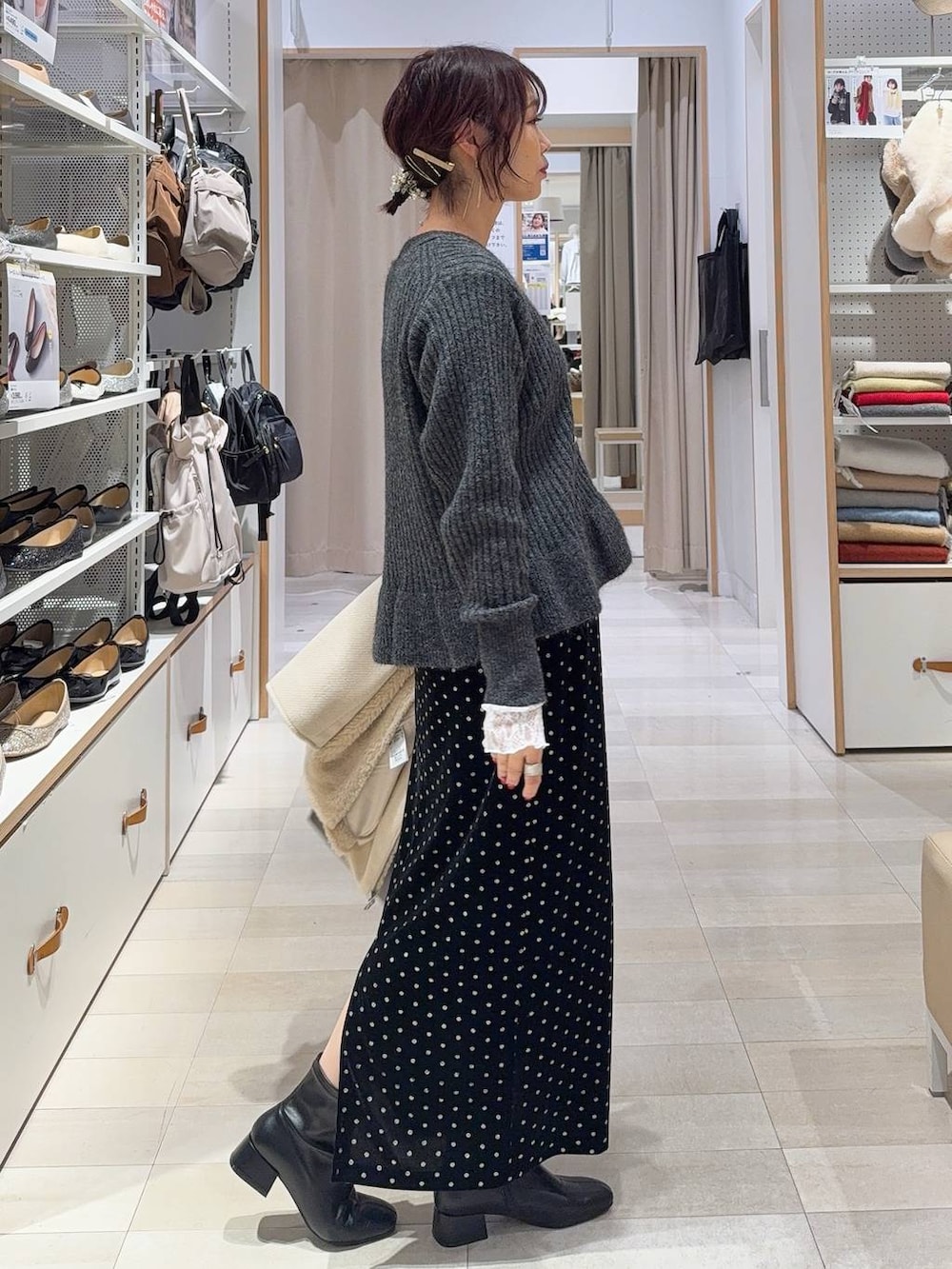 ブラウン系のボストンバッグ、ホワイト系のTシャツ/カットソー、ブラック系のスカートを着用したレディースの秋コーディネートの7枚目の写真