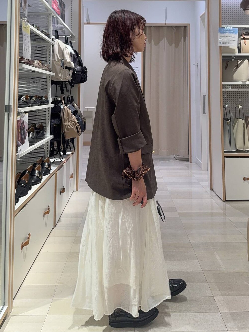 ブラック系のローファー、ホワイト系のキャミソール、ブラウン系のテーラードジャケットを着用したレディースの秋コーディネートの8枚目の写真