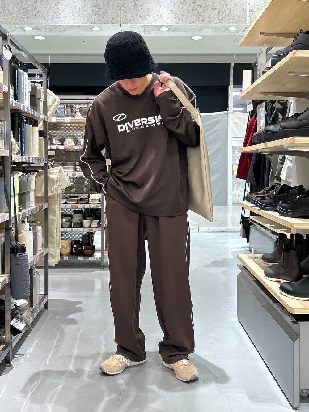 グレー系のトートバッグ、ブラウン系のその他パンツ、ブラウン系のTシャツ/カットソーを着用したメンズの秋コーディネートの7枚目の写真