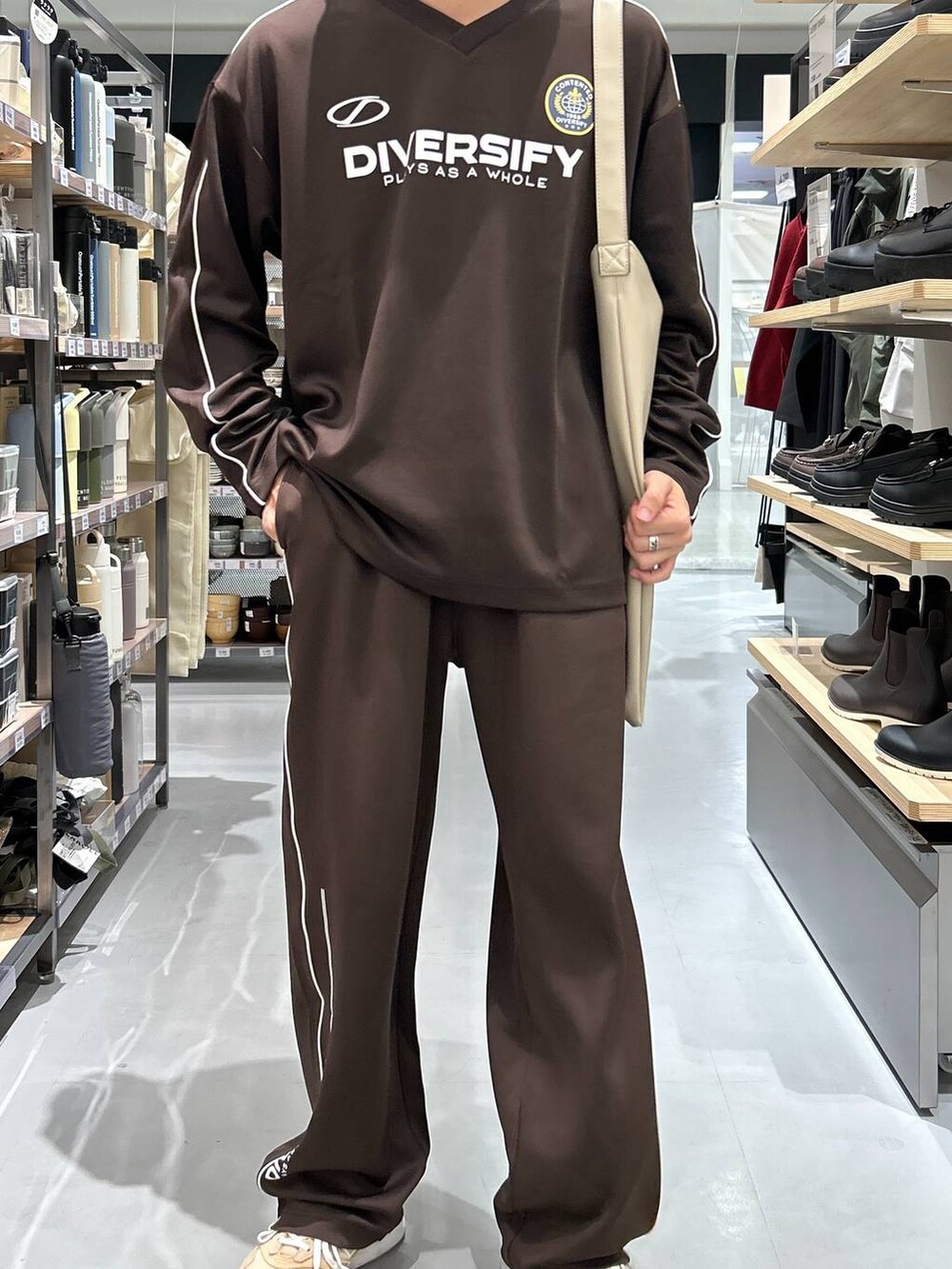 グレー系のトートバッグ、ブラウン系のその他パンツ、ブラウン系のTシャツ/カットソーを着用したメンズの秋コーディネートの3枚目の写真