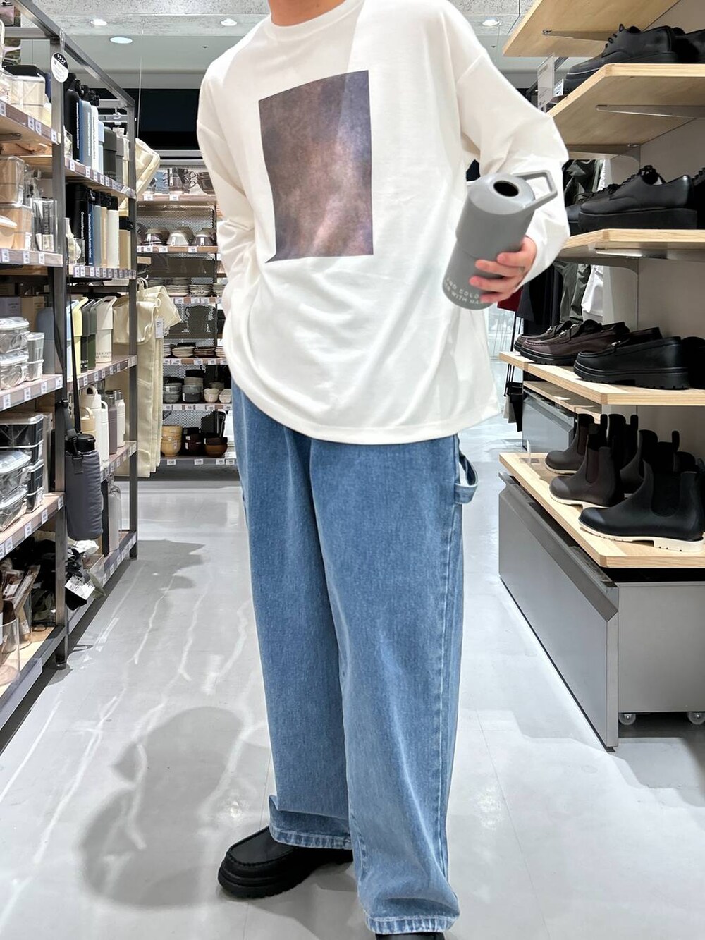 ブルー系のデニムパンツ、ホワイト系のTシャツ/カットソー、ブラック系のローファーを着用したメンズの秋コーディネートの2枚目の写真
