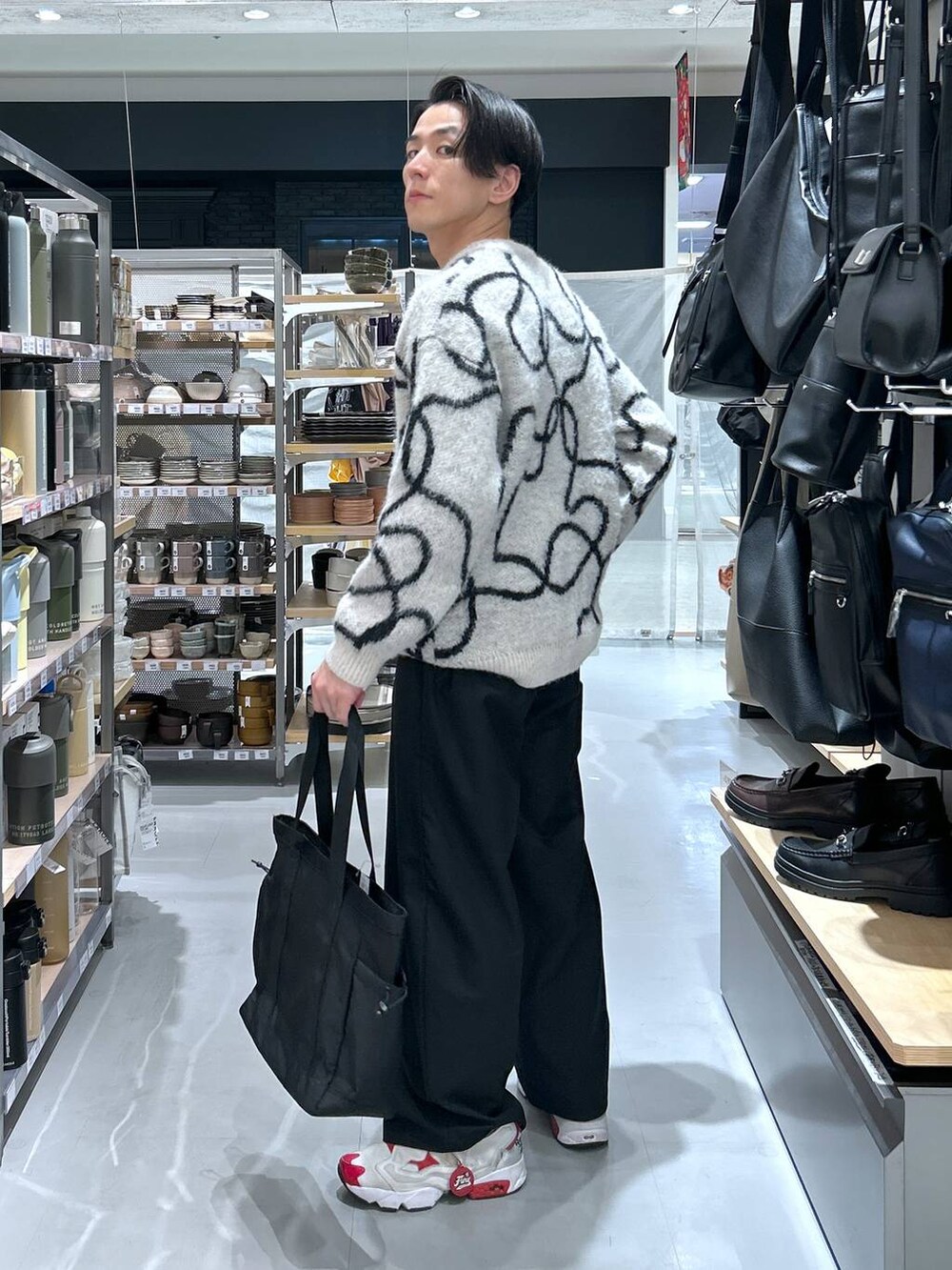 ブラック系のトートバッグ、ホワイト系のニット/セーター、ブラック系のその他パンツを着用したメンズの冬コーディネートの5枚目の写真