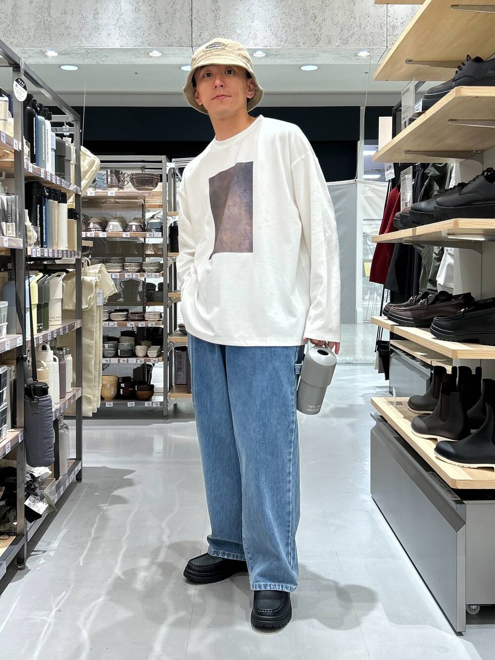 ブルー系のデニムパンツ、ホワイト系のTシャツ/カットソー、ブラック系のローファーを着用したメンズの秋コーディネートの4枚目の写真