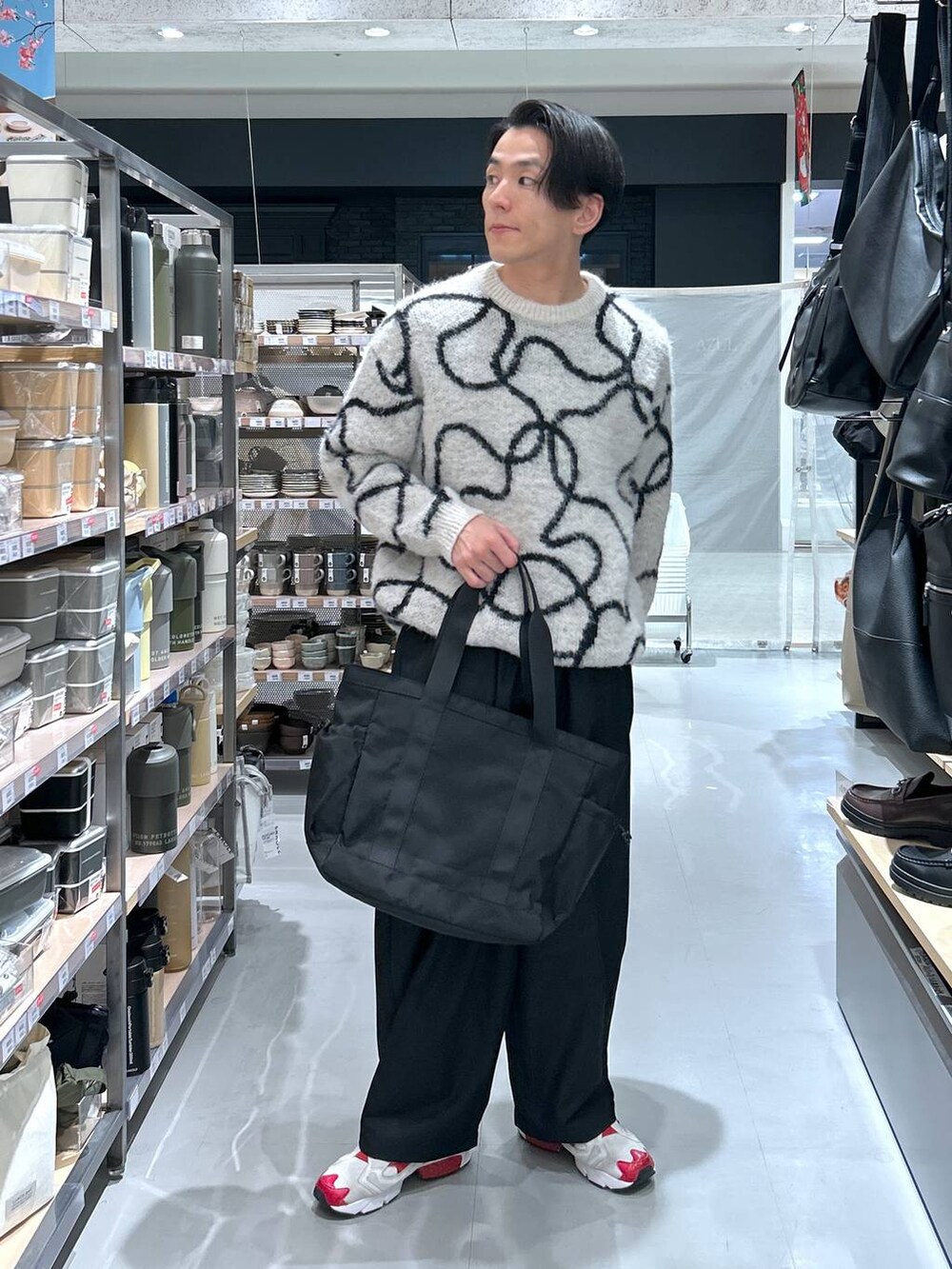 ブラック系のトートバッグ、ホワイト系のニット/セーター、ブラック系のその他パンツを着用したメンズの冬コーディネートの6枚目の写真