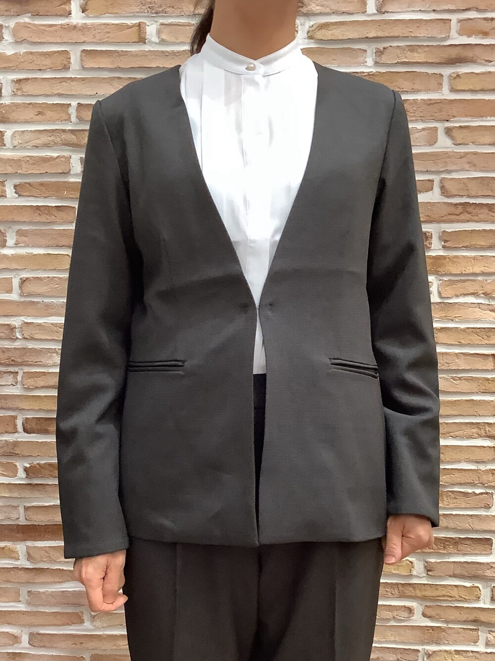 ブルー系のシャツ/ブラウス、グレー系のノーカラージャケット、グレー系のスラックスを着用したレディースの秋コーディネートの2枚目の写真