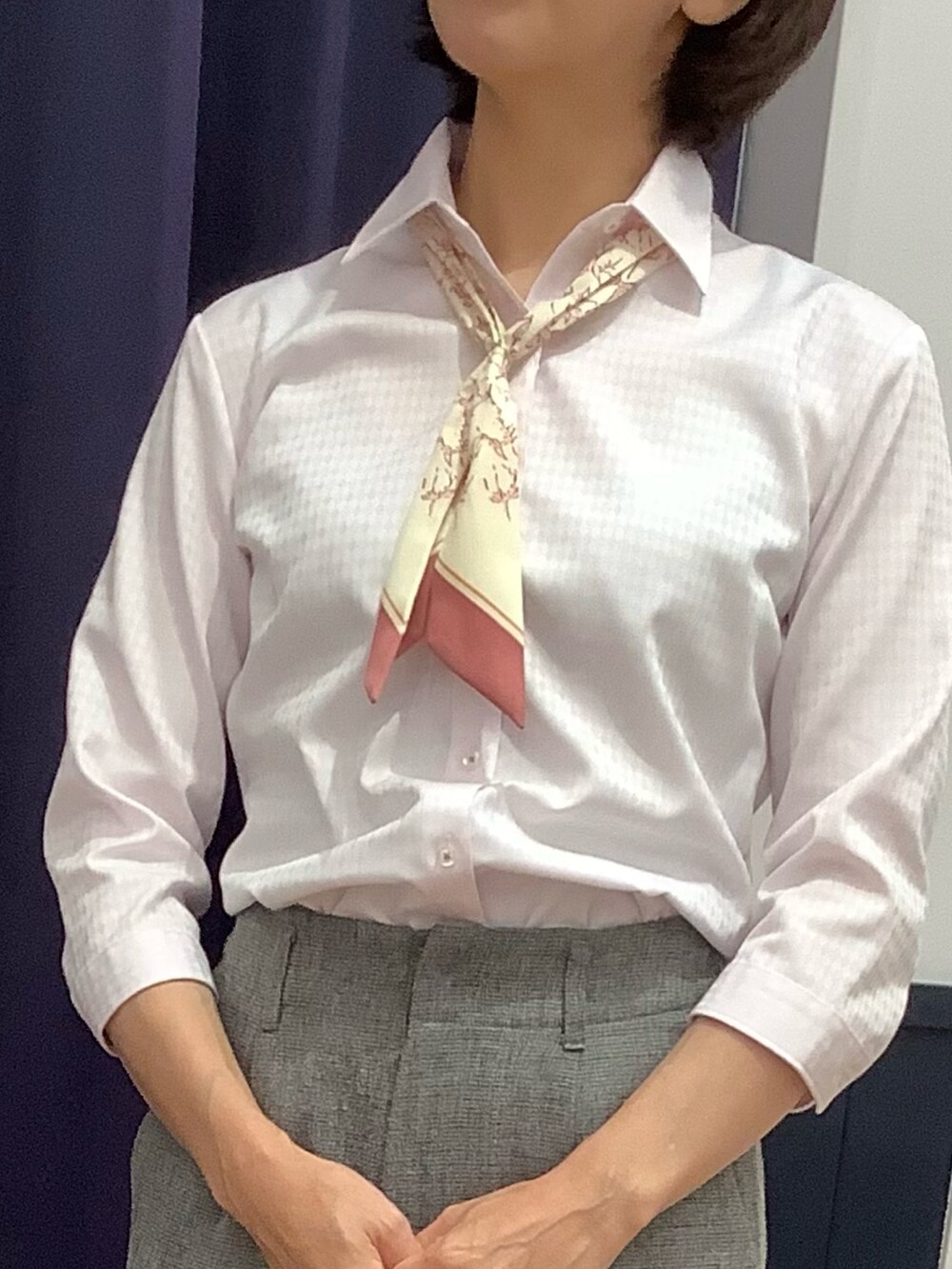 ピンク系のビジネスシャツを着用したレディースの夏コーディネートの2枚目の写真