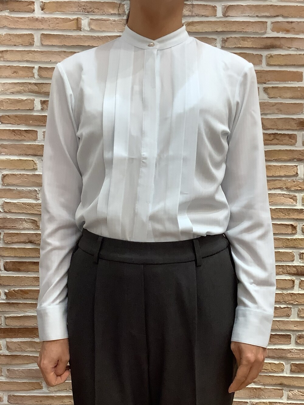 ブルー系のシャツ/ブラウス、グレー系のノーカラージャケット、グレー系のスラックスを着用したレディースの秋コーディネートの3枚目の写真