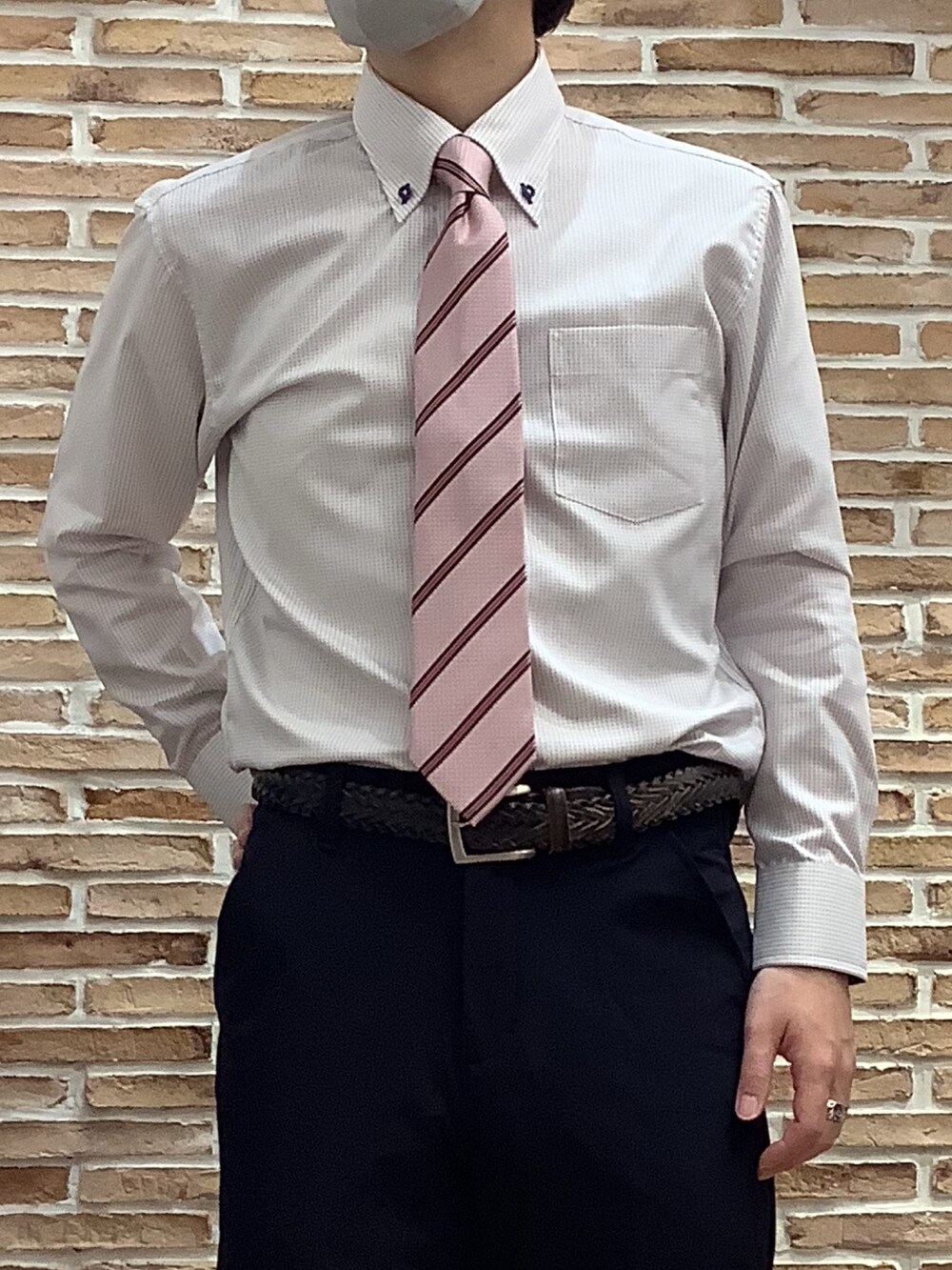 レッド系のビジネスシャツ、ピンク系のネクタイを着用したメンズの春コーディネートの2枚目の写真