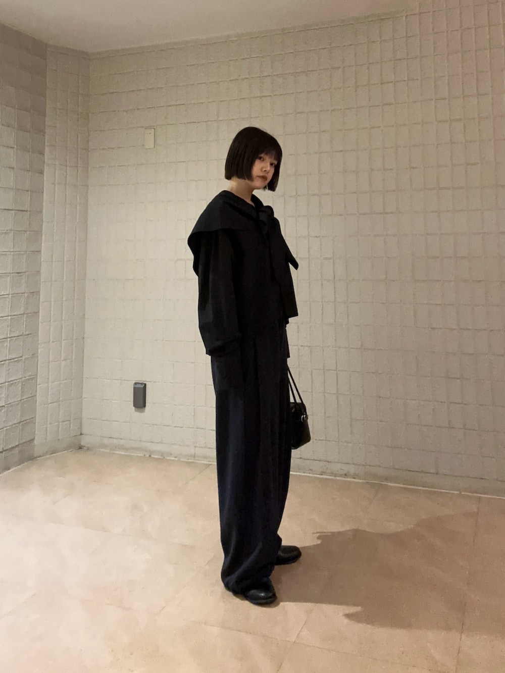 ブルー系のその他パンツ、ブラック系のシャツ/ブラウス、ブラック系のショルダーバッグを着用したレディースの春コーディネートの3枚目の写真