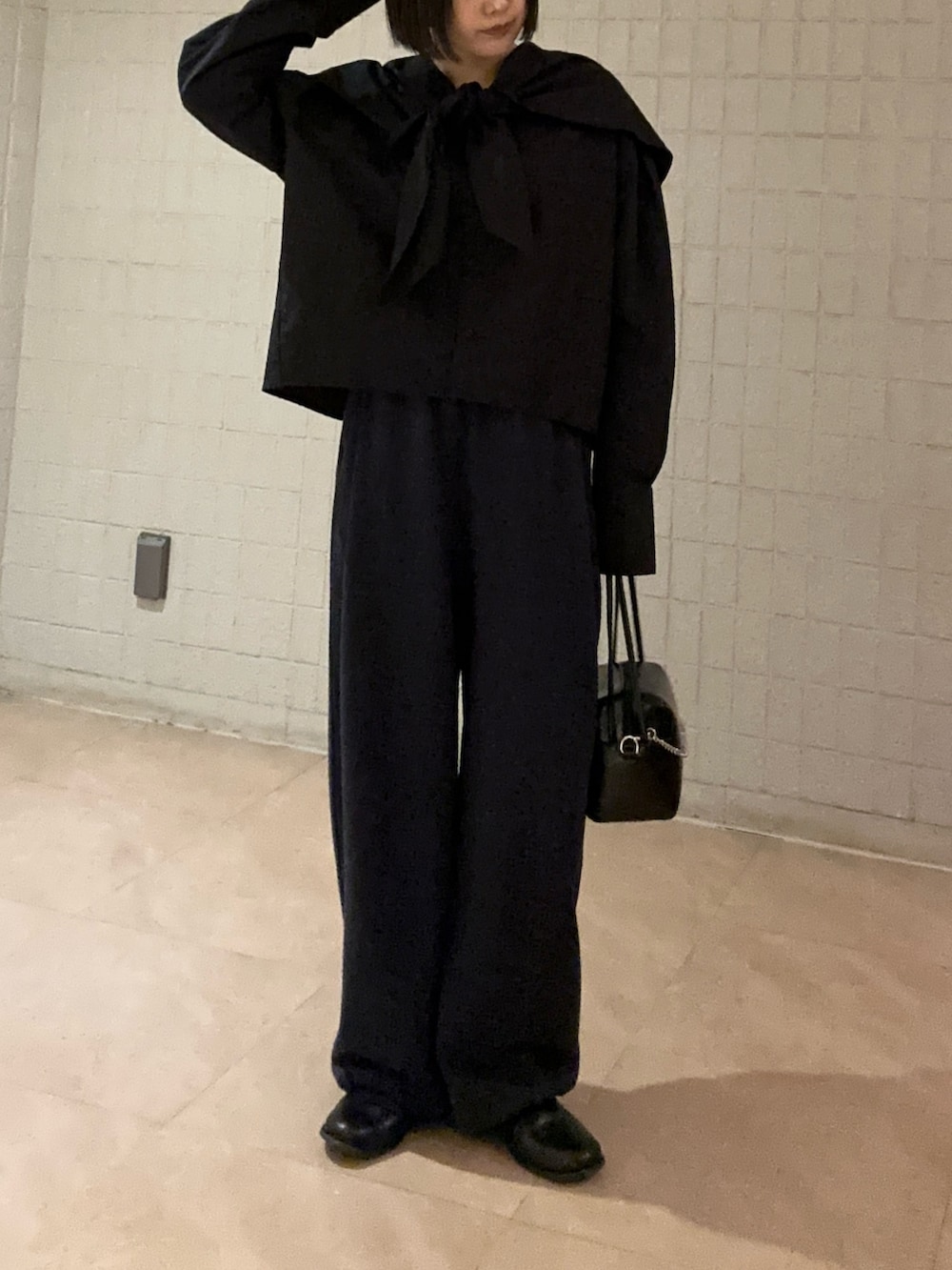 ブルー系のその他パンツ、ブラック系のシャツ/ブラウス、ブラック系のショルダーバッグを着用したレディースの春コーディネートの4枚目の写真