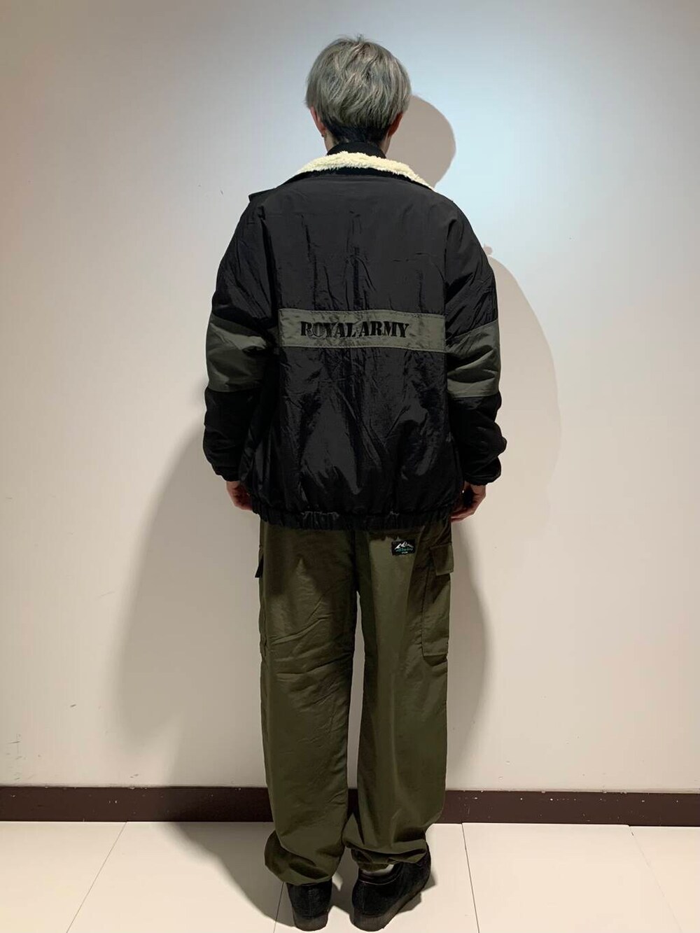 グリーン系のその他パンツ、ブラック系のニット/セーター、ブラック系のナイロンジャケットを着用したメンズの冬コーディネートの2枚目の写真