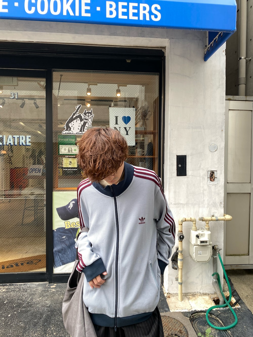 ブラック系のスラックス、ベージュ系のスニーカー、ブルー系のジャケット/アウターを着用したメンズの秋コーディネートの2枚目の写真