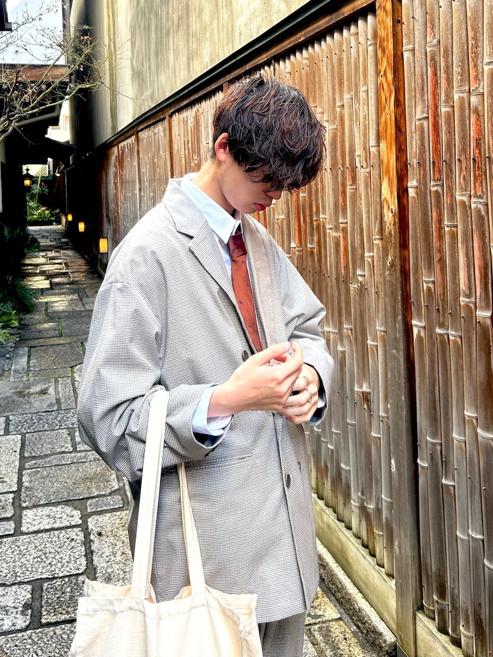 ベージュ系のスニーカー、ベージュ系のスラックス、グレー系のテーラードジャケットを着用したメンズの冬コーディネートの2枚目の写真