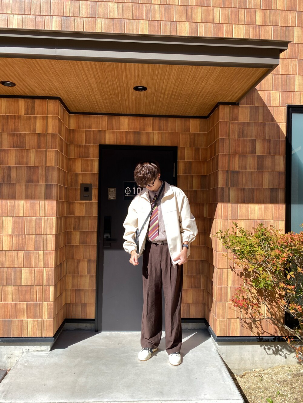 ホワイト系のライダースジャケットを着用したメンズの秋コーディネートの2枚目の写真