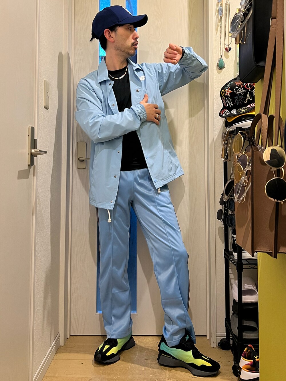 ブルー系のデニムパンツ、ブラック系のスニーカー、ブルー系のキャップを着用したメンズの春コーディネートの3枚目の写真