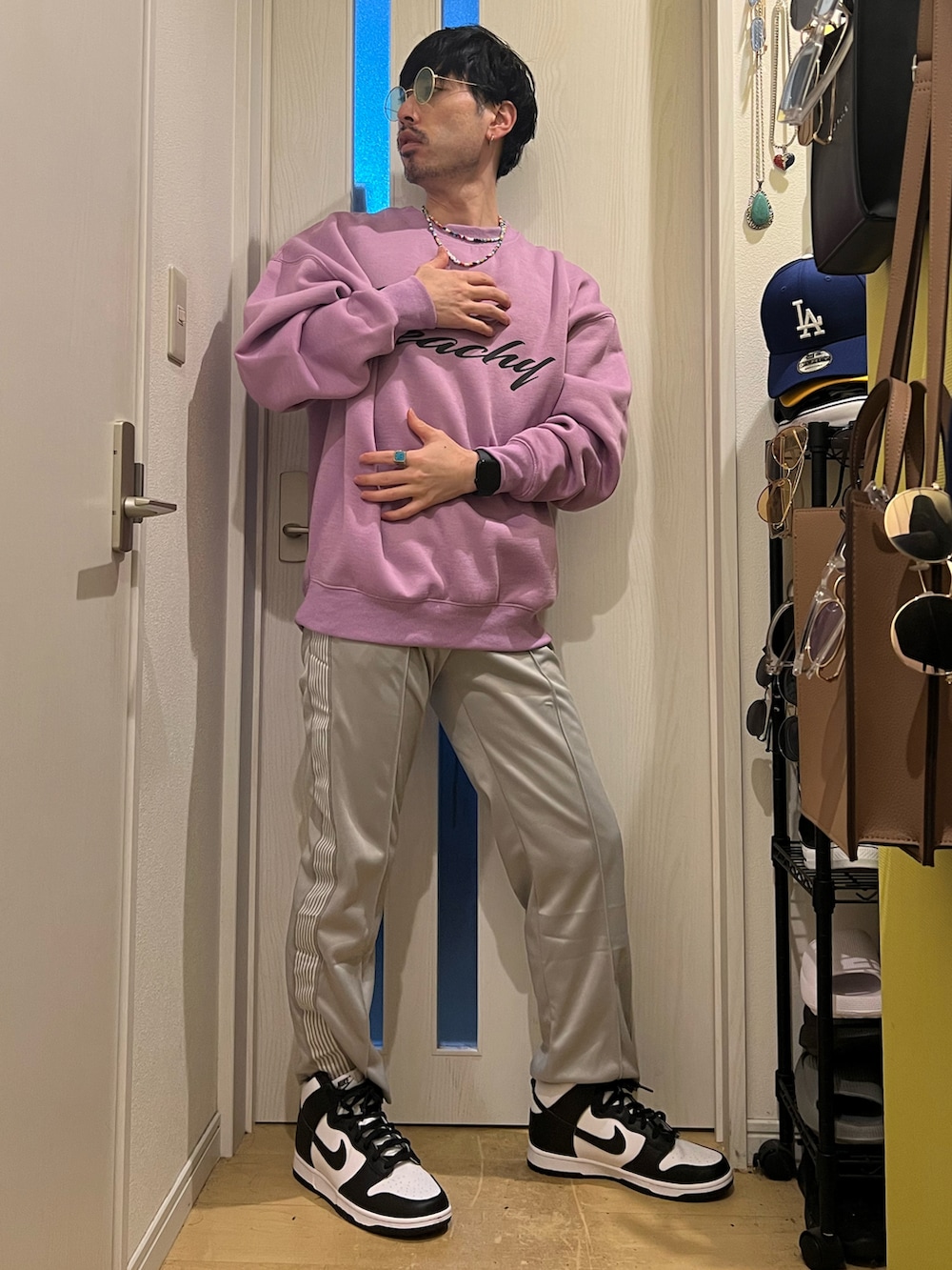 パープル系のスウェット、グレー系のデニムパンツ、ホワイト系のスニーカーを着用したメンズの春コーディネートの2枚目の写真