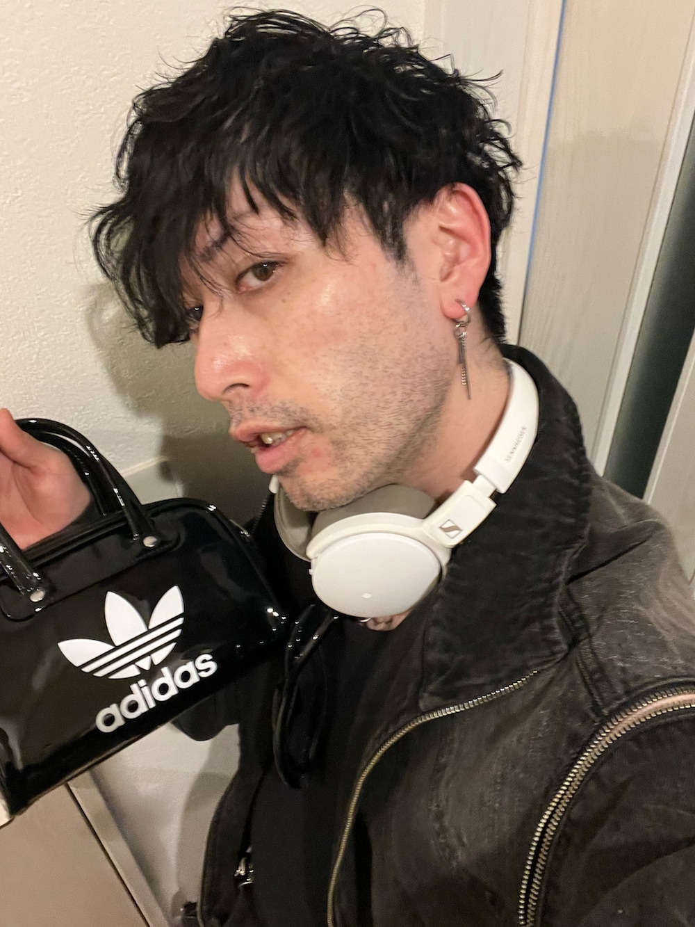 ブラック系のデニムパンツ、ベージュ系のブーツ、ブラック系のデニムジャケットを着用したメンズの春コーディネートの5枚目の写真