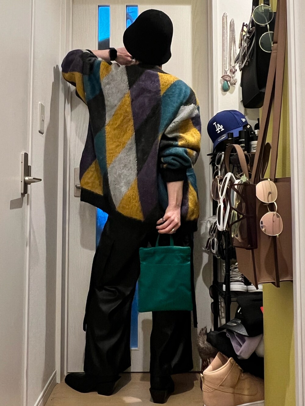 ブラック系のカーゴパンツ、ブラック系のブーツ、グリーン系のショルダーバッグを着用したメンズの春コーディネートの3枚目の写真