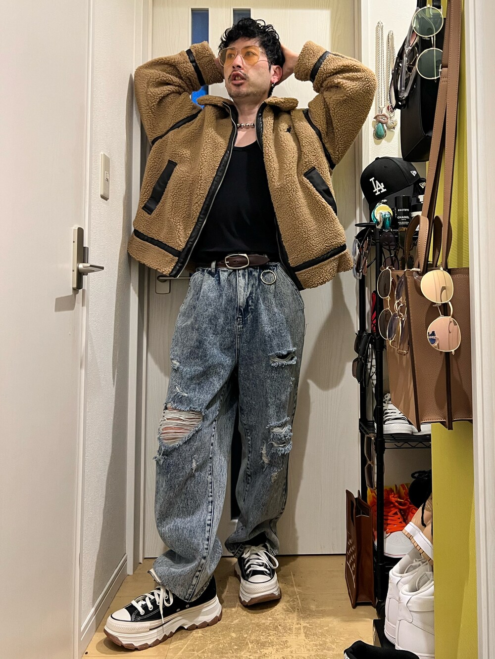 ブラウン系のハンドバッグ、ブルー系のデニムパンツ、ブラック系のスニーカーを着用したメンズの冬コーディネートの3枚目の写真