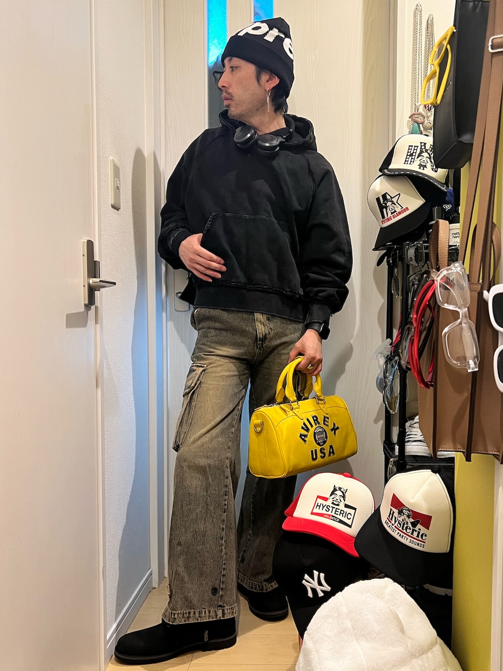 イエロー系のボストンバッグ、ブルー系のカーゴパンツ、ブラック系のブーツを着用したメンズの冬コーディネートの2枚目の写真