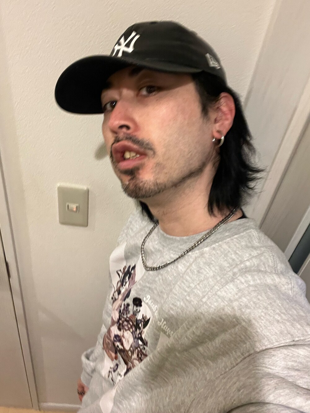 ブラウン系のデニムパンツ、ホワイト系のスニーカー、グレー系のスウェットを着用したメンズの冬コーディネートの4枚目の写真