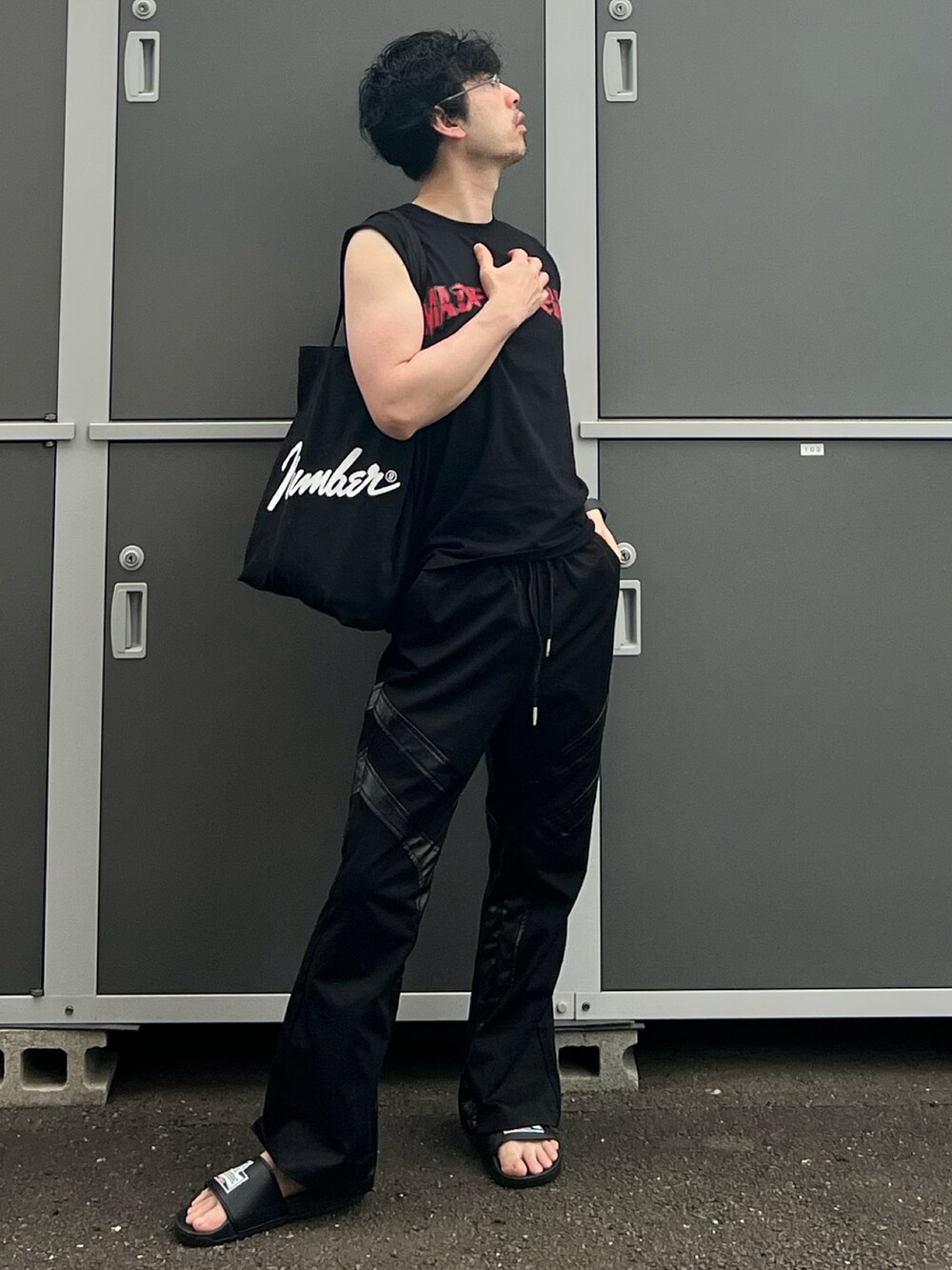 ブラック系のトートバッグ、ブラック系のタンクトップ、ブラック系のパンツを着用したメンズの夏コーディネートの5枚目の写真