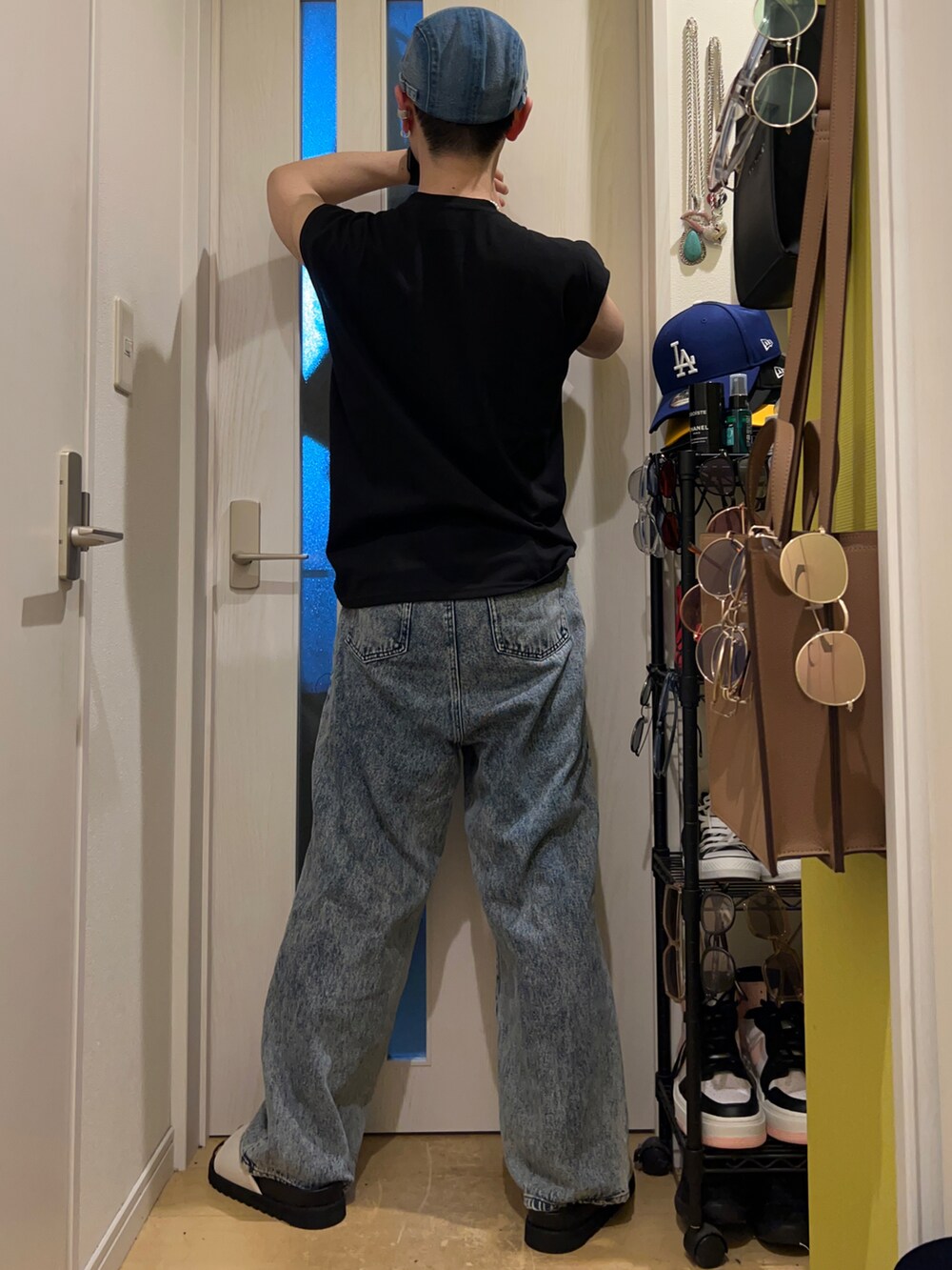 ブルー系のデニムパンツ、ホワイト系のサンダル、ブラック系のタンクトップを着用したメンズの夏コーディネートの4枚目の写真