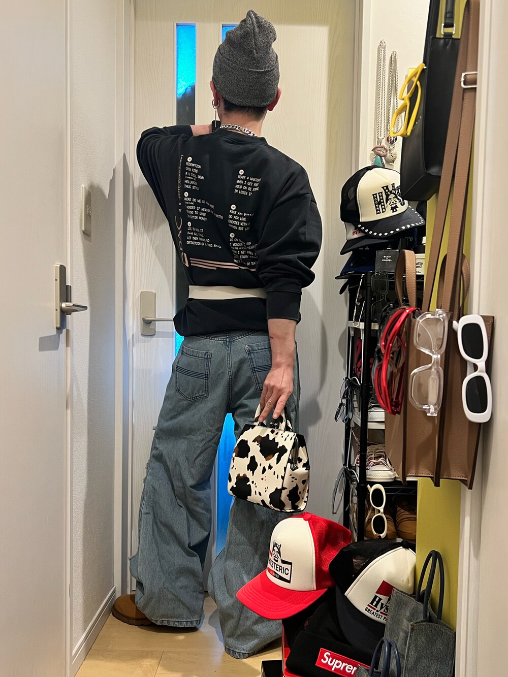 ブルー系のデニムパンツ、ホワイト系のショルダーバッグ、ブラック系のスウェットを着用したメンズの冬コーディネートの3枚目の写真