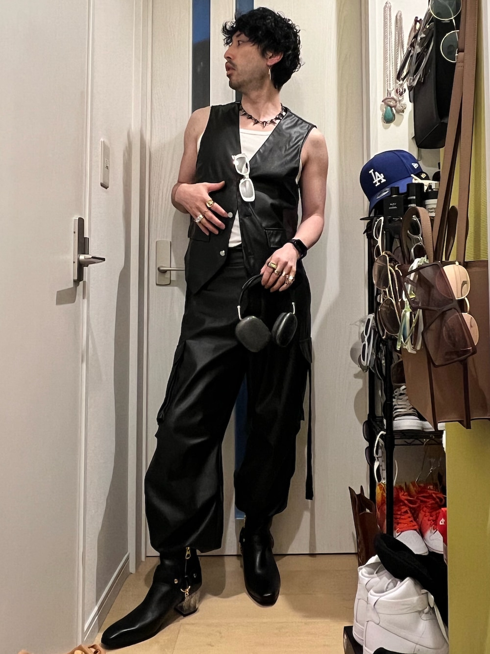 ブラック系のカーゴパンツ、ブラック系のブーツ、ブラック系のベストを着用したメンズの春コーディネートの2枚目の写真