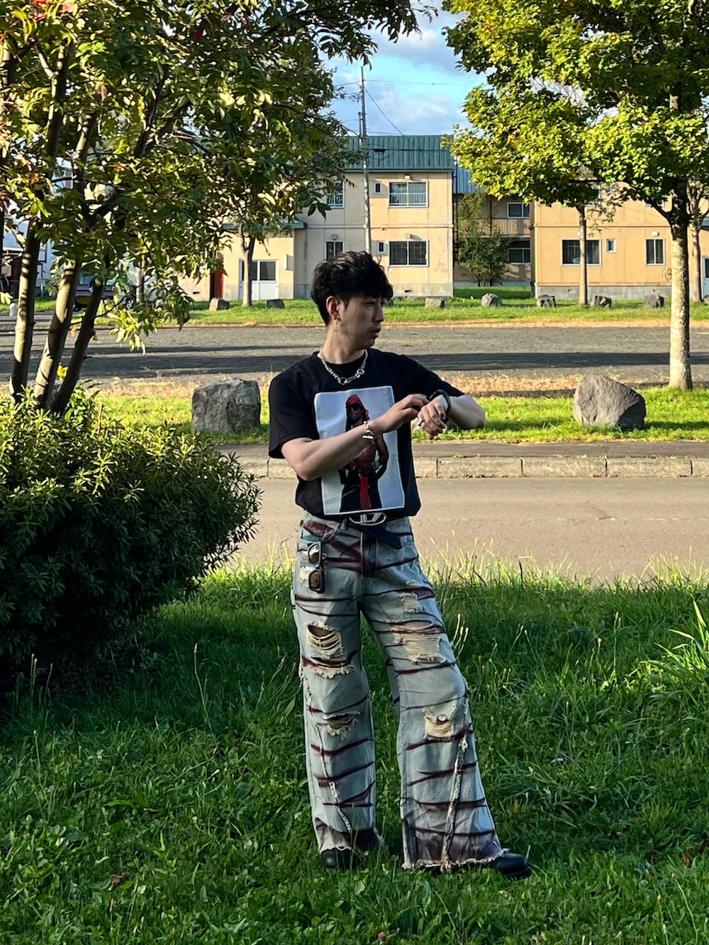 ブルー系のデニムパンツ、ブラック系のブーツ、ブラック系のTシャツ/カットソーを着用したメンズの秋コーディネートの4枚目の写真