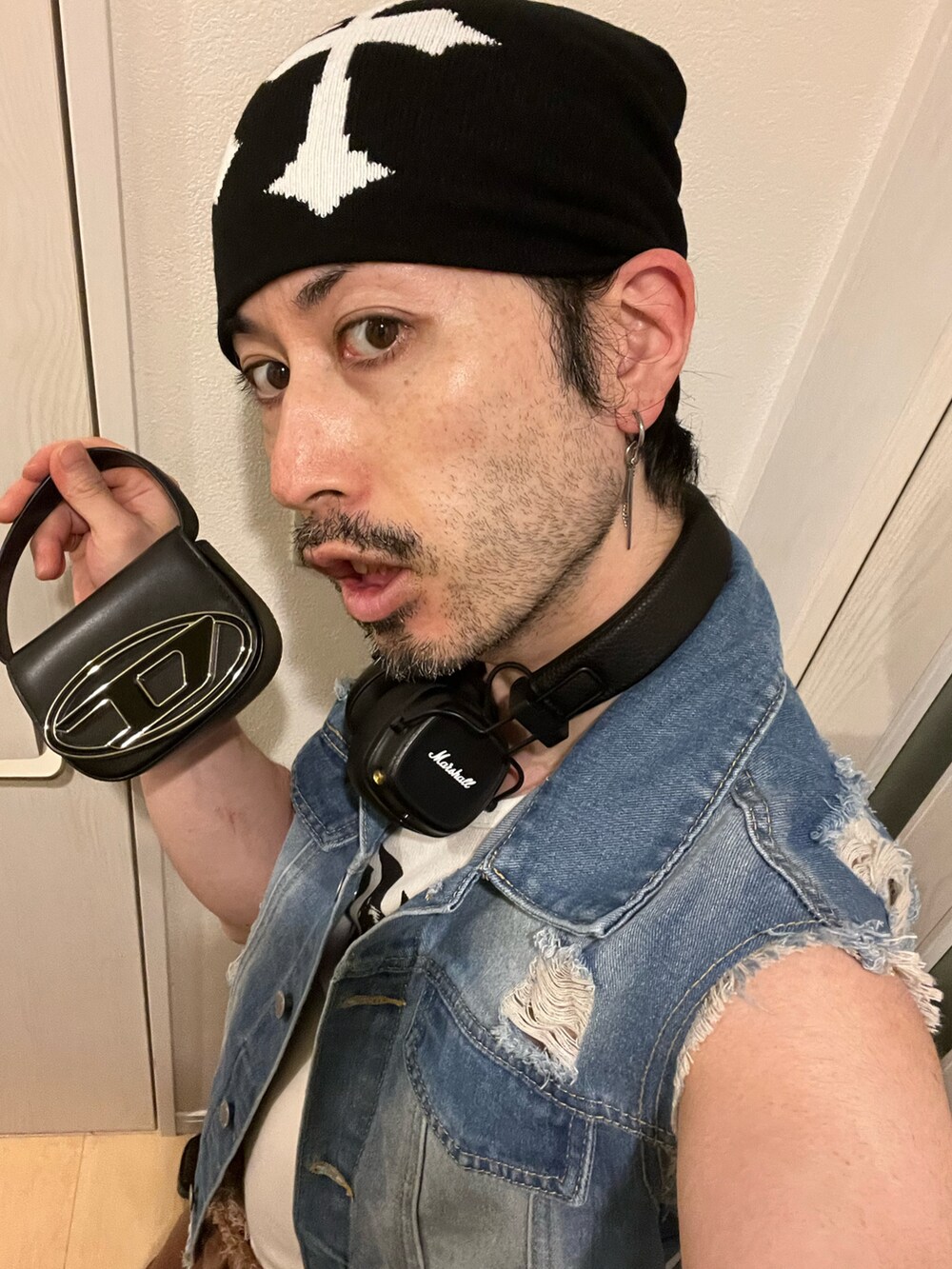 ブラック系のショルダーバッグ、ブラック系のブーツ、ホワイト系のタンクトップを着用したメンズの夏コーディネートの4枚目の写真