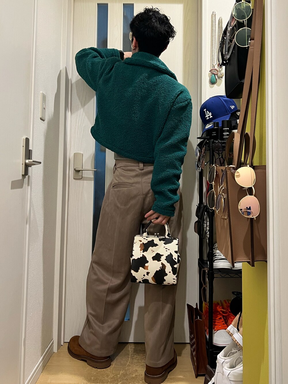 グリーン系のジャケット/アウター、ホワイト系のショルダーバッグ、ベージュ系のスラックスを着用したメンズの冬コーディネートの3枚目の写真