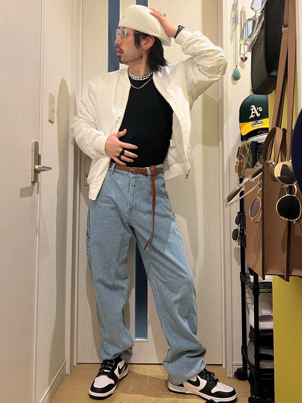 ブルー系のデニムパンツ、ホワイト系のMA-1、ホワイト系のスニーカーを着用したメンズの冬コーディネートの2枚目の写真