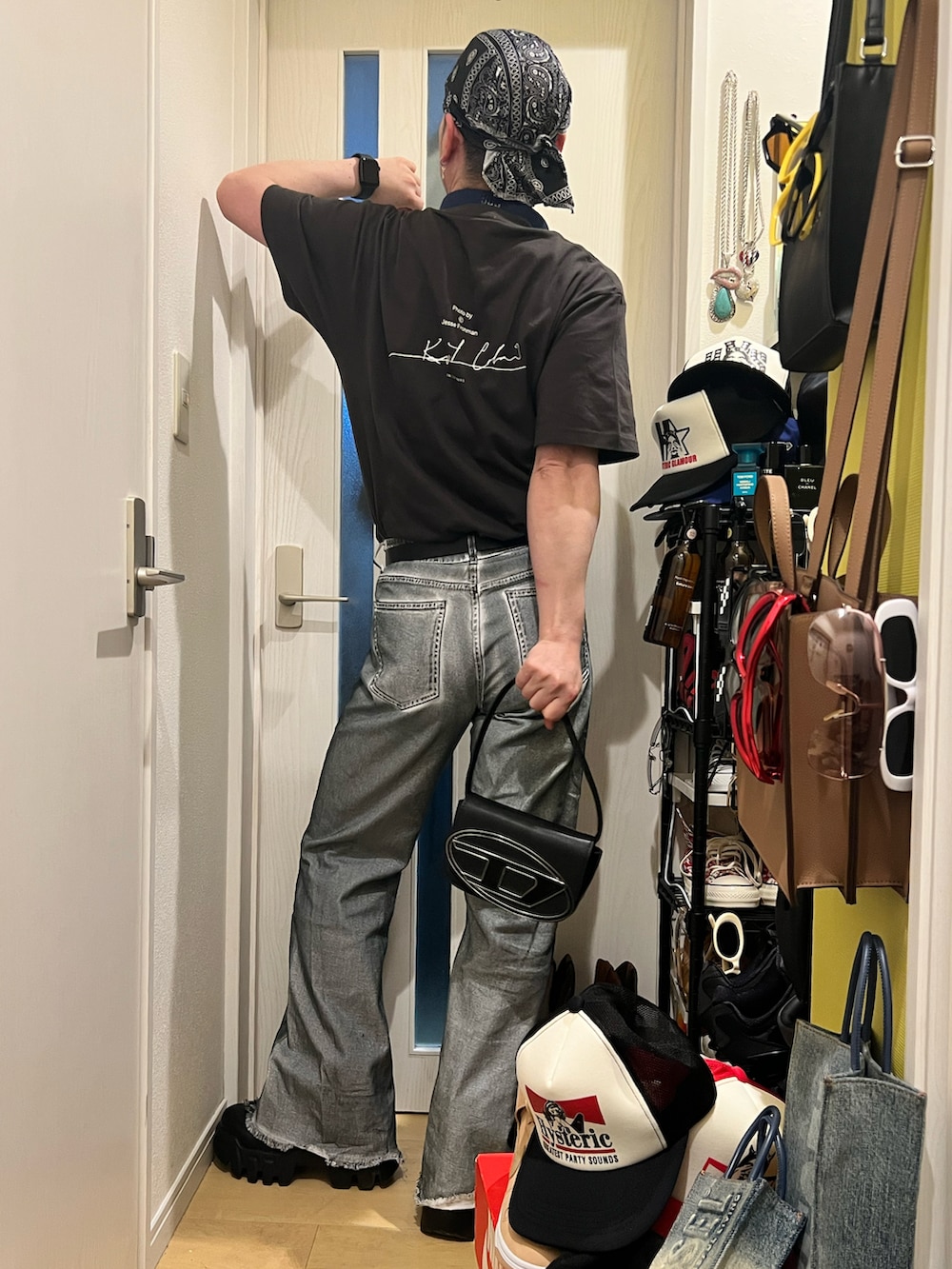 ブラック系のTシャツ/カットソー、ブラック系のショルダーバッグ、ブラック系のブーツを着用したメンズの春コーディネートの2枚目の写真