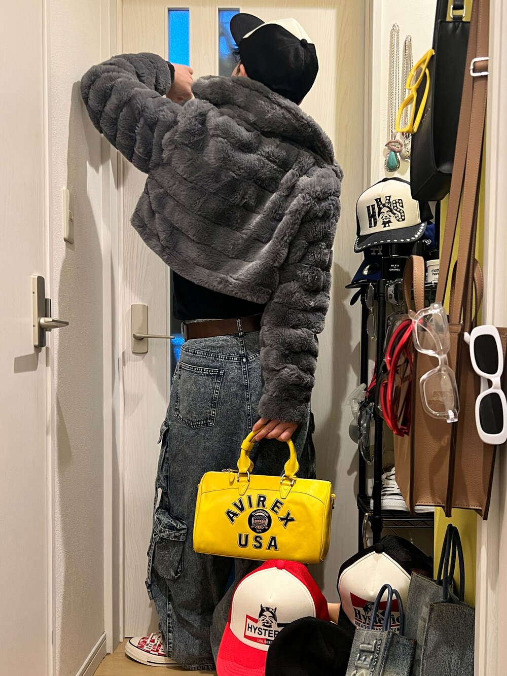 イエロー系のボストンバッグ、ブルー系のカーゴパンツ、レッド系のスニーカーを着用したメンズの冬コーディネートの3枚目の写真